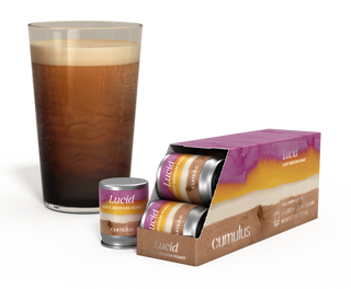 An opened pack of Lucid light-medium roast coffee capsule next to a cup of coffee