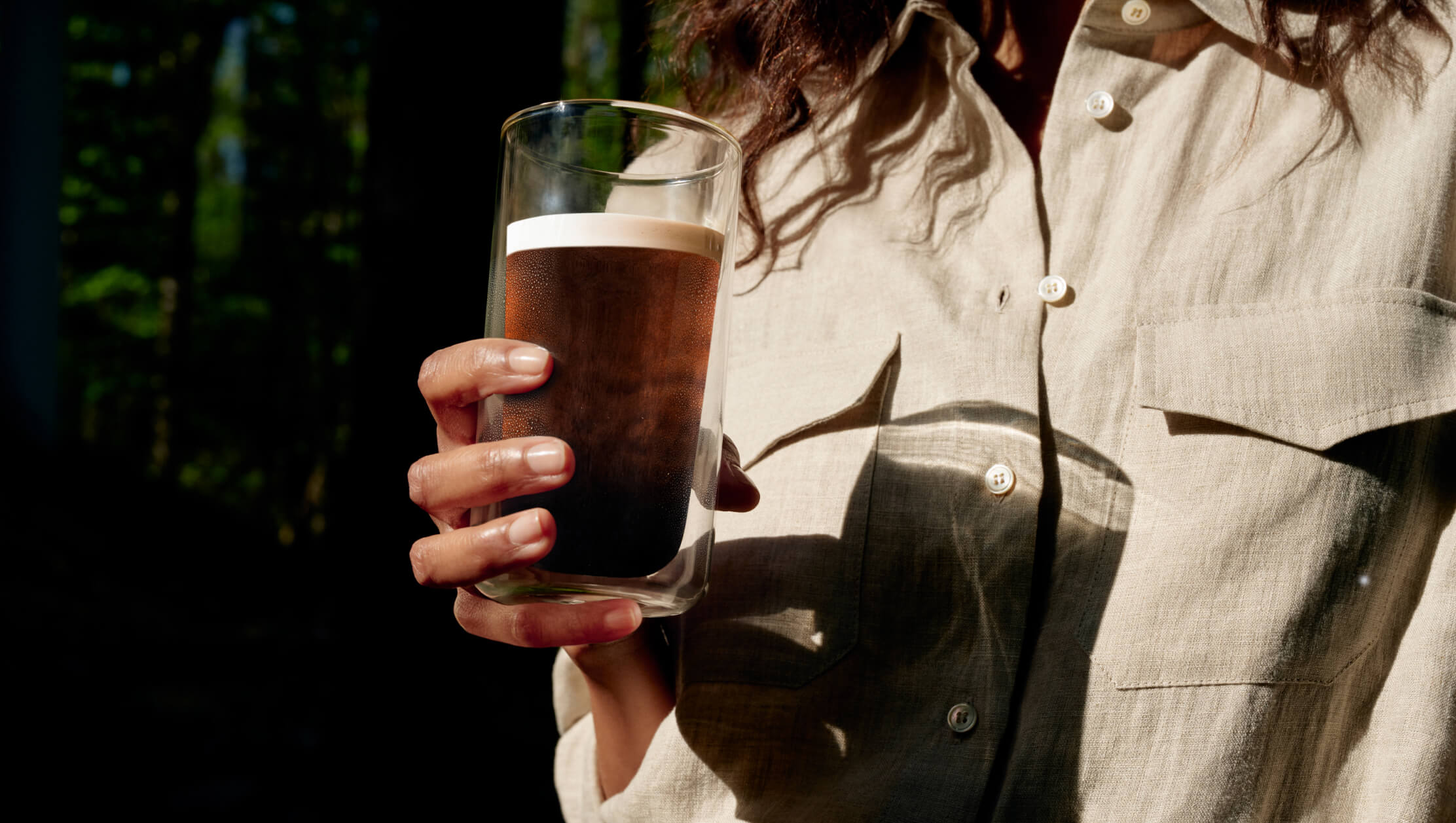 Woman holding a glass of Cumulus Coffee cold brew