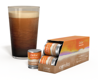 An opened pack of Delve medium roast coffee capsule next to a cup of coffee