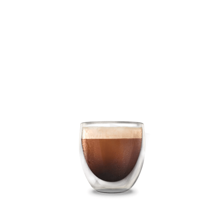 A tall glass containing espresso cold brew coffee with a head of foam.