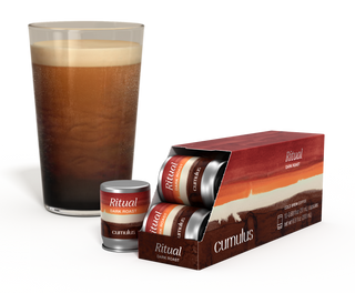 An opened pack of Ritual dark roast coffee capsules next to a cup of coffee