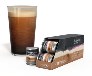 An opened pack of Sospeso light roast coffee capsule next to a cup of coffee