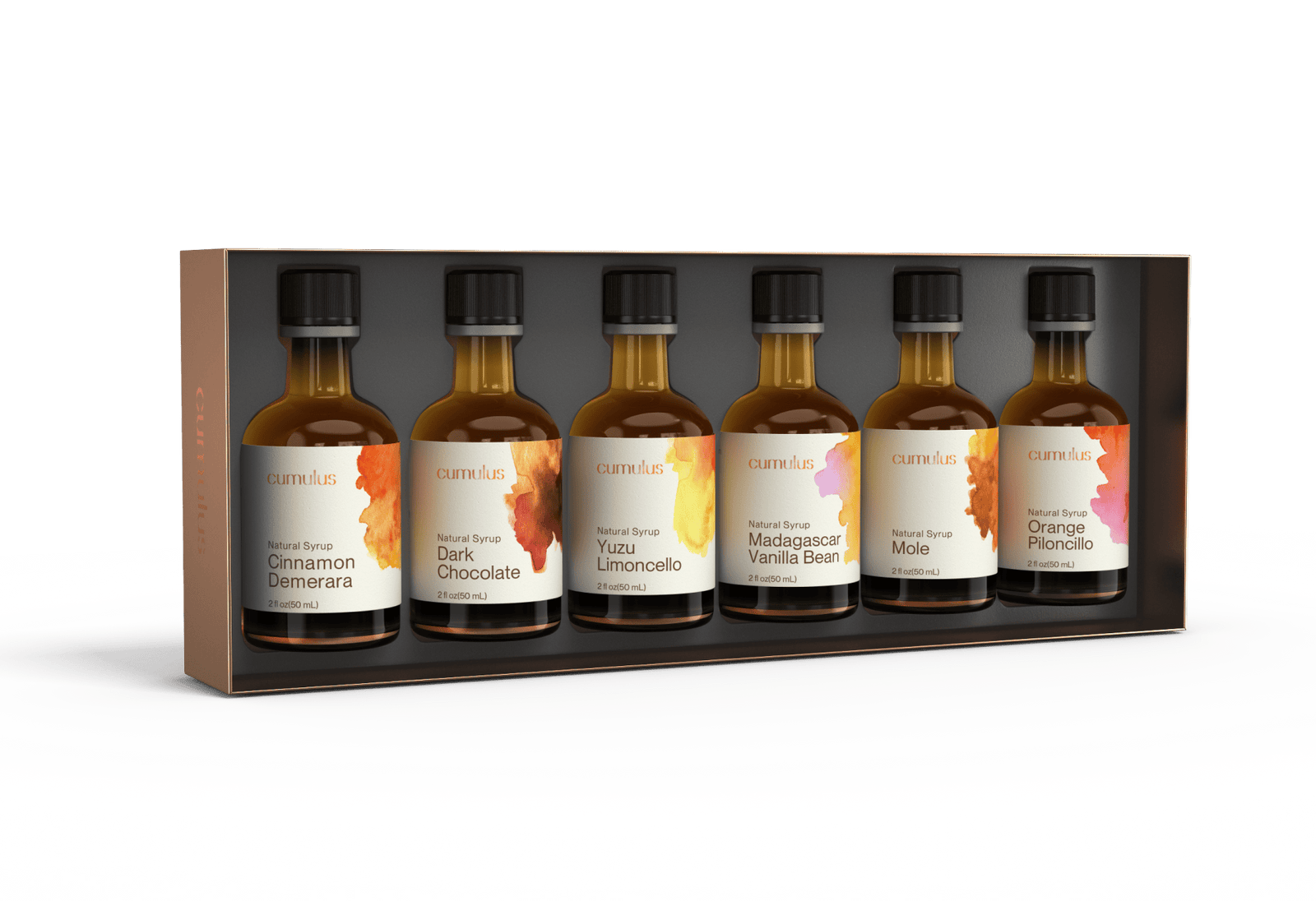 A set of six cumulus flavor syrup bottles sitting in a box. The labels say "Cinnamon Demerera", "Dark Chocolate", "Yuzu Limoncello", "Madagascar Vanilla Bean", "Mole" and "Orange Piloncillo". Each bottle is 2oz or 50ml.
