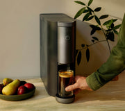 Man retrieving a completed cup of coffee from a Cumulus machine