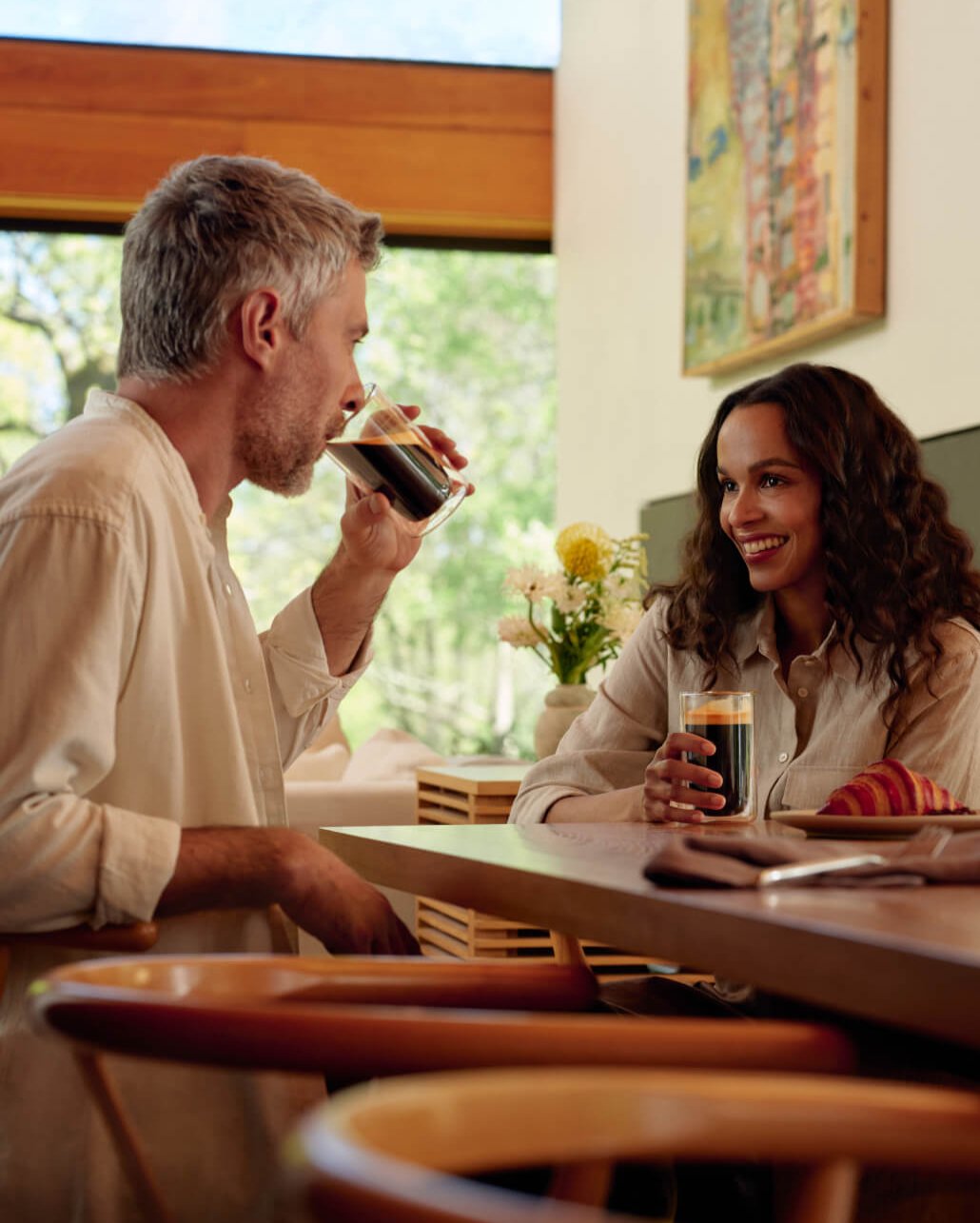 A man and a woman enjoying coffee together at a table